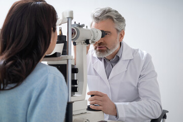 Male optician testing woman sight and providing eye consultation