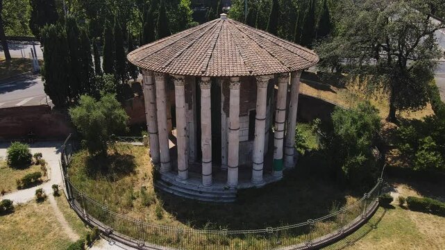 Iconic circular Roman temple with marble columns standing amid historic ruins