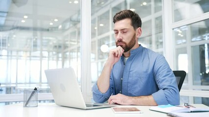 Thoughtful businessman working on laptop in business office. Manager thinking about problem solving sitting at workplace. An entrepreneur is engaged in a task or is busy with a project on computer