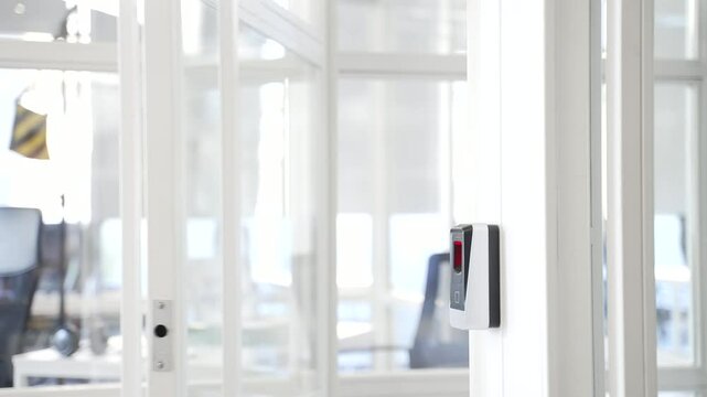 Close up of a man's hand opening a glass office door holding a doorknob in a modern business center. A man, businessman or employee in a shirt opens the door and enters office to workplace. Rear view