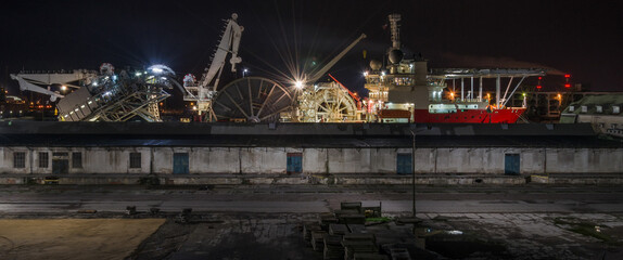 RED SHIP WITH A HELIPAD - Pipe laying vessel moored in seaport
