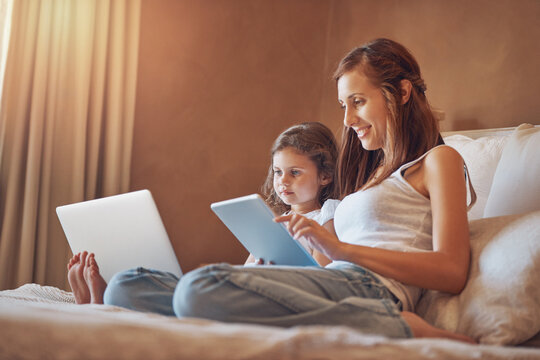 Mother, child and relax on bed with technology for streaming subscription, cartoons and online video in home. Happy family, woman and girl in bedroom with tablet, laptop and social media for bonding