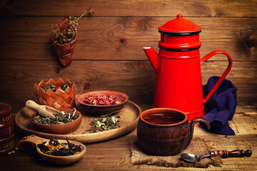 still life with vintage red metallic teapots and tea accessories on wooden table