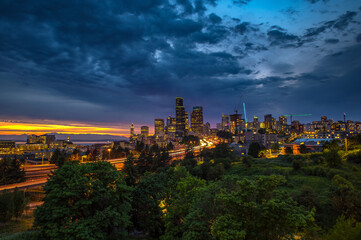 Seattle skyline illuminated at dusk, with vibrant city lights and streaking traffic on the I-5...