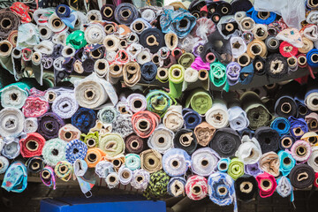 Rolls of textile fabric displayed for sale at Walthamstow market in London, England