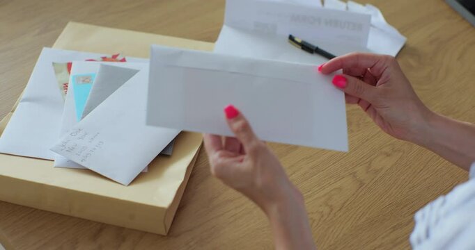 Woman received a letter with a greeting card. Close-up woman hands pull greeting card out envelope.