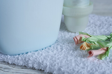 Laundry conditioner and towels on wooden background. Selective focus.