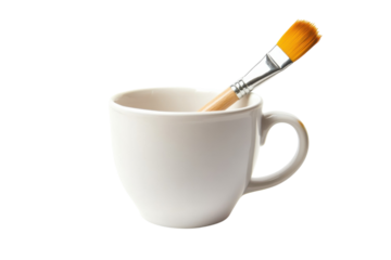 A creative morning ritual with a paintbrush resting in a white cup on a bright surface