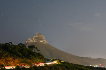 Lion's Head at Night: A majestic silhouette of Lion's Head mountain, its peak illuminated under a...