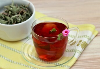 Cup of herbal infusion from Cistus incanus, known as rock rose. Traditional herbal tea with many external and internal benefits. Beautiful pink rock rose bud in tea.