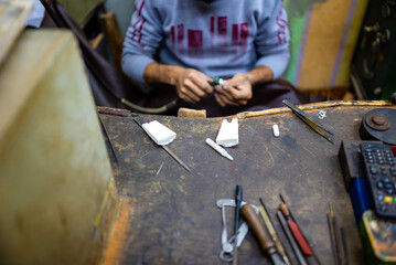 Close up view of a Jewelry maker busy making a piece of jewelry.