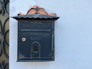 Vintage Mailbox Mounted on a White Wall in a City