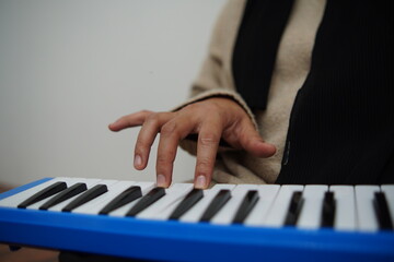 Obraz premium Anonymous woman playing pianica, melodica blow organ