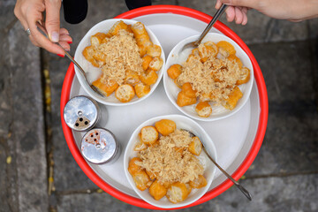 Top view of traditional Vietnamese porridge with fried dough sticks and pork floss, served in white bowls on a red tray, ready to enjoy as a local breakfast.