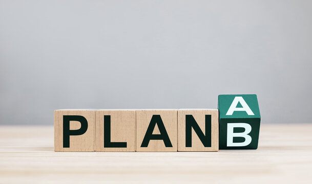 Rows of wooden cubes change from Plan A to Plan B on a wooden table. Concept of planning, contingency plans and risk management with backup plans.
