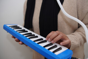 Anonymous woman playing pianica, melodica blow organ