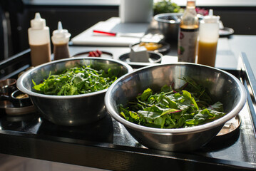 Bowls with various microgreens standing on table, restaurant kitchen
