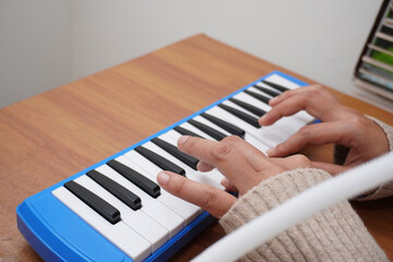Anonymous woman playing pianica, melodica blow organ