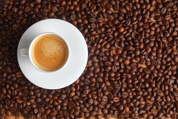 Top view of Espresso in a White Cup Surrounded by Toasted Coffee Beans