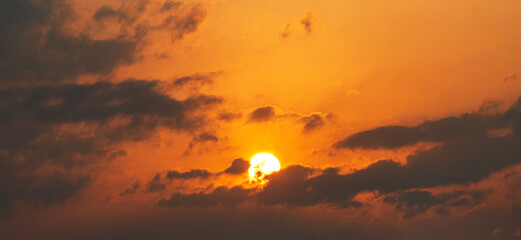 Sun sets behind the clouds, beautiful bright sunset sky with dramatic clouds. Sunset sky background.