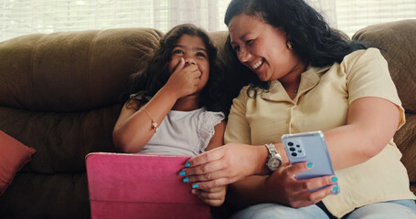 Mother and Daughter Bonding Over Smartphone and iPad on Cozy Couch. High quality photo