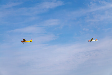 an airplane pulling on the glider line against the background of a beautiful blue sky.