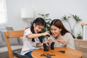 Family Fun and Interaction. Engaging in a lively domino game, a mother shares joyful moments with her daughter.