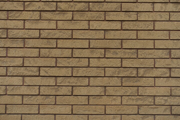 Texture of beige split face brick veneer wall with running bond layout