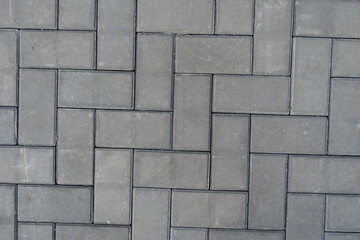Close view of grey concrete pavement with single herringbone layout