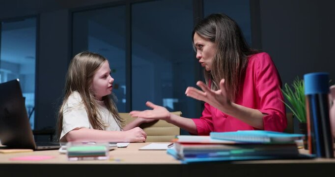 Nervous mother argues with daughter about homework completion at desk at night. Woman talks to schoolgirl failing on exam leaning at home slow motion