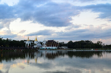 Naklejka premium Golden Pagoda and Church, Lanna Architecture in Evening vibes with natural landscapes at Wat Pa Ratchadaram in Lamphun, Northern Thailand