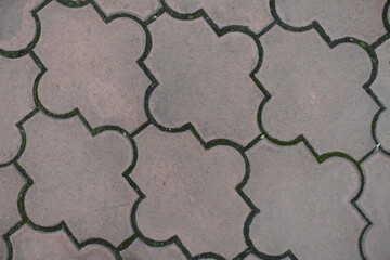 Closeup of pale pink pavement of interlocking concrete tiles with moroccan lattice layout