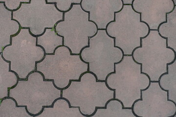 Top view of pale pink pavement of interlocking concrete tiles with moroccan lattice layout
