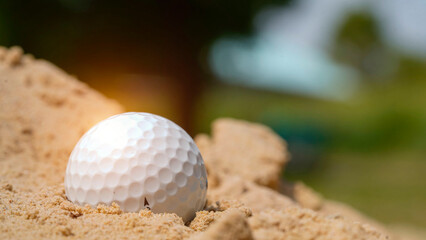 Golf ball on the sand in beautiful golf course at sunset background. © somchai