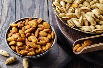 Almonds and shell in bowl on wooden table