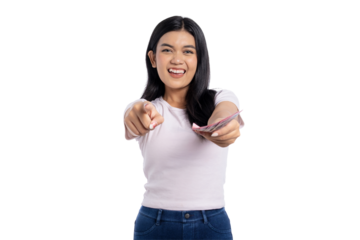 Happy young Asian woman pointing and smiling while holding Indonesian rupiah cash, isolated on transparent background