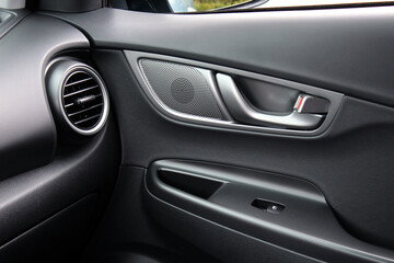 AC Ventilation Deck modern Car Interior. Door handle with windows control buttons of a electric passenger car. Black interior of the modern car.
