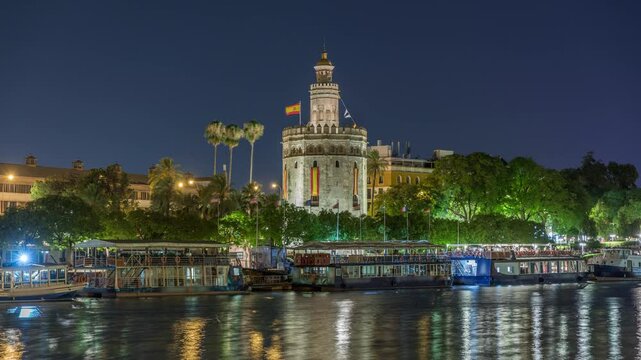 Torre del Oro timelapse hyperlapse, a dodecagonal military watchtower in Seville, Spain. Built by the Almohads to control Guadalquivir River access. Historic landmark with reflections at night.