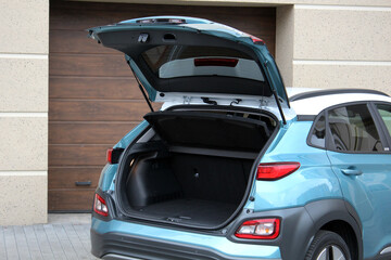 Blue elecric car is ready to load luggage. Modern electric SUV open trunk. Clean trunk SUV car. Open back door modern SUV. Car open trunk. Car boot is open.
