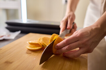 Slicing Fresh Oranges on a Beautiful Wooden Cutting Board to Enhance Your Culinary Skills