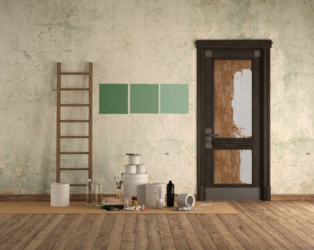 Painting supplies in room with three green swatches on wall