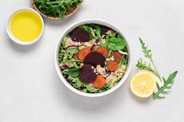 Quinoa salad with arugula, beetroot and carrot. Detox, diet, healthy salad in white bowl on light...
