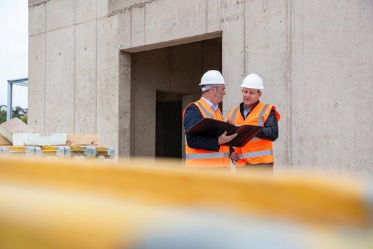 Engineers inspecting a shell construction site with blueprints
