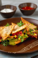 Nachos chips with sauces on a porcelain plate
