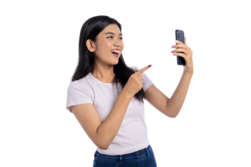 Happy young Asian woman taking a selfie and pointing at her smartphone, isolated on transparent background