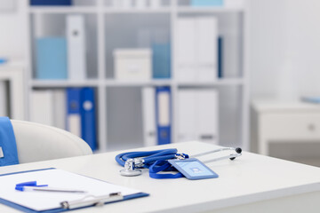 Doctor's workplace with stethoscope and paperwork on desk, closeup. Space for text