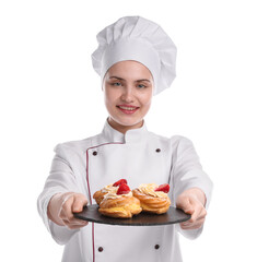Happy confectioner in uniform holding delicious profiteroles with strawberries on white background