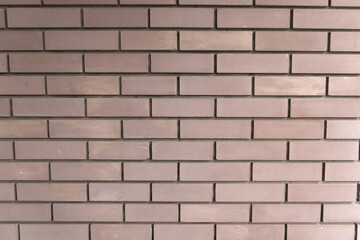 A uniform brick wall with a light brown color, showing a clean and structured pattern