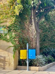 Colorful Recycling Bins in Eco-Friendly Urban Courtyard. Recycling Concept with Modern Color-Coded Bins Outdoors. 