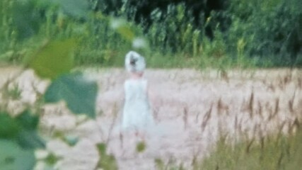 Little active girl child running on green beach nature. Happy childhood in summer park outdoor. Fun children games with parent mother. Vintage film. Carefree kid in family archive. Retro 1980s Ukraine